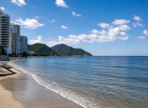 a view of a beach with buildings and the ocean at La Villa de Sofia in Santa Marta
