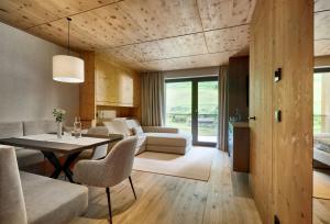 a dining room and living room with a table and chairs at Hotel Alpenhof in Tux