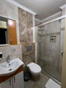 a bathroom with a shower and a toilet and a sink at Riwaner Hotel in Avcılar
