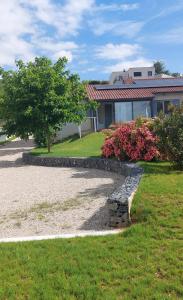 a house with a stone wall in front of a yard at Gite des Reguinelles in Saint-Lattier