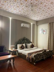 a bedroom with a large bed with a floral ceiling at HotelMaple Ridge in Tājganj