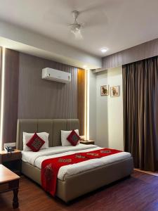 a bedroom with a large bed with red pillows at HotelMaple Ridge in Tājganj