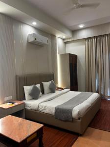 a bedroom with a large bed and a table at HotelMaple Ridge in Tājganj