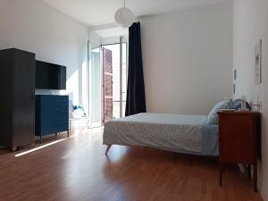 a bedroom with a bed and a dresser and a window at Studio64 in Civitavecchia