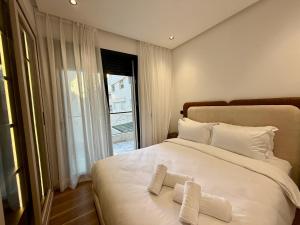 a bedroom with a large white bed with two pillows at Living Fleuri Suites & Studios in Casablanca