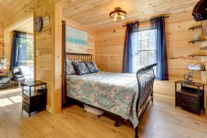 a bedroom with a bed in a log cabin at Fire Pit, Gas Grill! Bright Cottage By Devils Lake in Manitou Beach