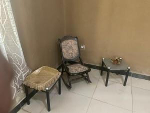 two chairs and a stool in a room at Djilani Global Hub in Dirē Dawa