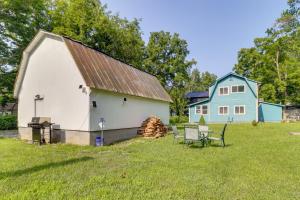 a barn with a table and chairs in a yard at Fire Pit, Gas Grill! Bright Cottage By Devils Lake in Manitou Beach
