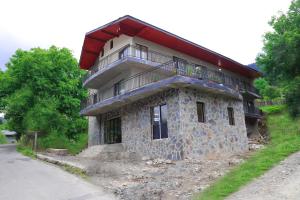a stone building with a balcony on top of it at Lalveri INN in Mestia