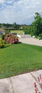 a park with a green lawn and pink flowers at Gite des Reguinelles in Saint-Lattier +3 photos