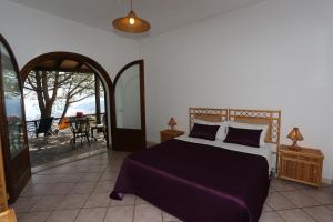 1 dormitorio con 1 cama y balcón en Eoliando Case per Vacanze - Lipari, en Lipari