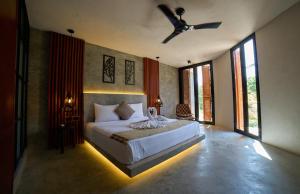 a bedroom with a bed with a ceiling fan at Casa del Viento by ÓOL Hotels in Holbox Island +85 photos