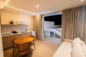 a room with a kitchen and a table and a couch at Landruá Flat in São Luís