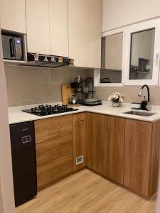 a kitchen with wooden cabinets and a stove top oven at Mini Apartment Ares 3 in Lima