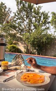 a person sitting at a table with a plate of carrots at Bubuli country club in Lyamutundwe