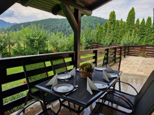 a black table with chairs on a balcony with a view at Carpen View Residence in Săcele