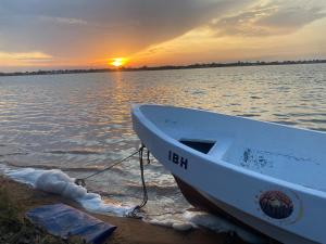 a boat sitting on the shore of a body of water at Hôtel Royal Malango in Fatick