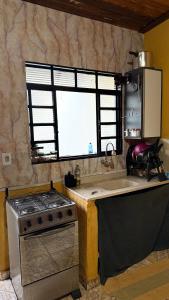 a kitchen with a stove and a sink and a window at Casa in Barretos