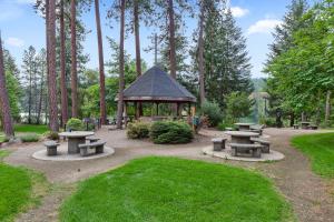 a group of picnic tables and a gazebo in a park at Riverside Harbor House in Post Falls ID in Post Falls