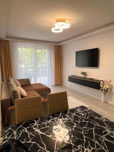 a living room with a couch and a flat screen tv at Apartament White Tower in Ploieşti
