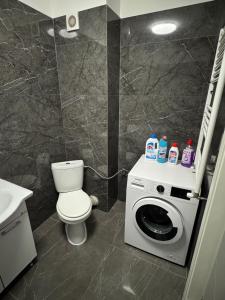 a bathroom with a toilet and a washing machine at Apartament White Tower in Ploieşti +7 photos