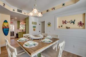 a dining room with a wooden table and white chairs at 275 Ohio in Fort Myers Beach