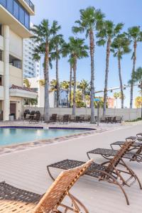 a pool with chaise lounge chairs and palm trees at Pier House 60 Clearwater Beach Marina Hotel in Clearwater Beach