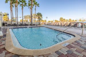 a swimming pool with palm trees in a resort at Pier House 60 Clearwater Beach Marina Hotel in Clearwater Beach