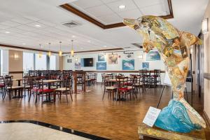 a dining room with tables and chairs and a statue at Pier House 60 Clearwater Beach Marina Hotel in Clearwater Beach