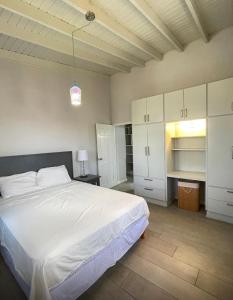 a bedroom with a large bed and white cabinets at Brightridge Condos in Bridgetown