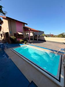 a swimming pool in front of a house at Casa de Temporada Ipê Rosa in Bonito