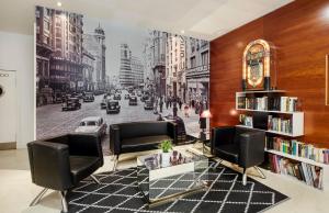 a living room with a wall mural of a city street at Sercotel AB Rivas in Rivas-Vaciamadrid