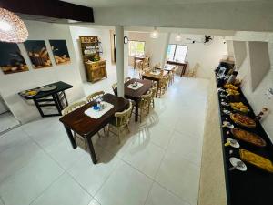a dining room with tables and chairs in a room at Pousada Sal e Mar Maracaipe in Porto De Galinhas