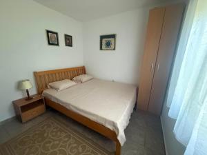 a small bedroom with a bed and a window at Apartman LUCIJA, dostupan minimum 7 NOCENJA i VISE, AVAIBLE FOR RENT MINIM 7 NIGHTS AND MORE in Sutomore