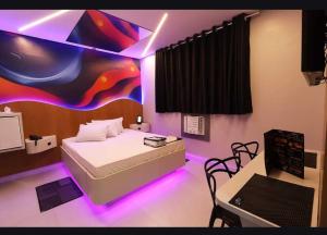a bedroom with a bed with purple lights in it at HOTEL KARINHO - Próximo ao Allianz Parque in São Paulo