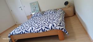 a bed with a blue and white comforter on it at Guesthouse Thibault in Gistel