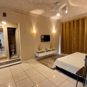 a bedroom with a bed and a tv on the wall at Casa Aconchego! in Uberaba