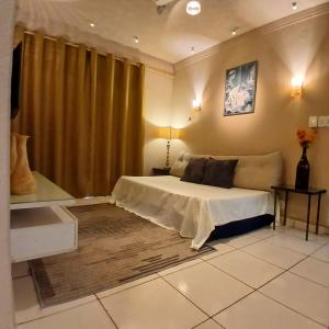 a bedroom with a bed in a room with curtains at Casa Aconchego! in Uberaba