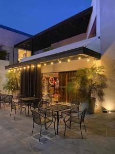 a group of tables and chairs in front of a building at Grann Hotel in Ciudad Valles
