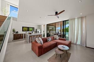 a living room with a brown couch and a kitchen at Long Lap Pool - Modern Villa - Jan Thiel Beach in Jan Thiel