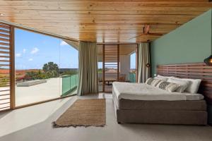 a bedroom with a large bed and a balcony at Long Lap Pool - Modern Villa - Jan Thiel Beach in Jan Thiel +92 photos