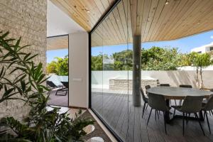 a glass extension of a house with a table and chairs at Long Lap Pool - Modern Villa - Jan Thiel Beach in Jan Thiel