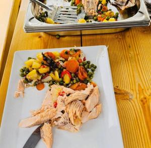 a plate of food with meat and vegetables on a table at Pensiunea Cascada in Borşa +32 photos