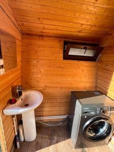a bathroom with a sink and a washing machine at Orbis Bude in Samshvilde +6 photos