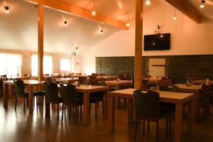 a restaurant with tables and chairs and a tv on the wall at Hótel Búrfell in Vík