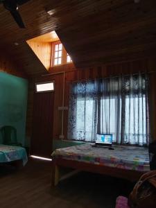 a laptop computer sitting on a bed in a room at Saamiyanaa Cloud Nest in Kalimpong +4 photos