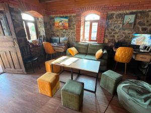 a living room with a couch and a table and stool at Orbis Bude in Samshvilde