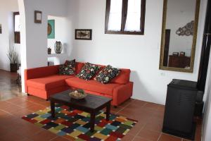 a living room with a red couch and a coffee table at Casa Rural "La Molina" in Máguez