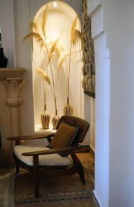 a laptop sitting on a chair with a table with vases at Villa Marrakech Beldi in Najem