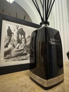 a black vase sitting on a table with a picture at Villa Marrakech Beldi in Najem +6 photos